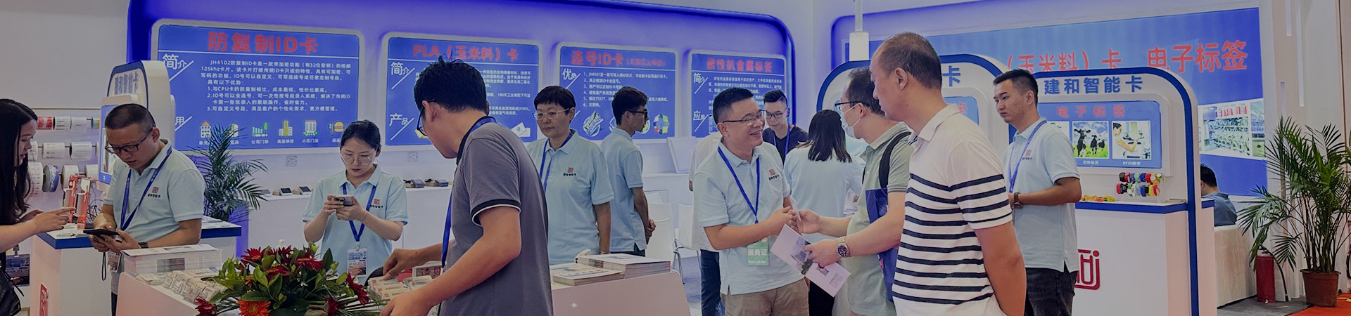 A bustling trade show booth showcases advanced NFC cards and proximity cards, alongside cutting-edge RFID readers and hotel key cards, attracting industry professionals to explore innovative solutions.